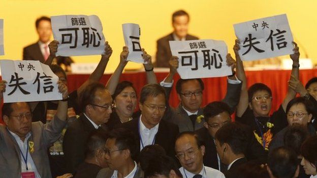 Pro-democracy lawmakers display placards against Li Fei, deputy secretary general of the National People's Congress' Standing Committee, during a briefing session in Hong Kong Monday, 1 Sept 2014