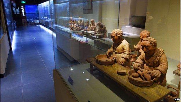 This photo taken on 24 July 2014 shows clay figures portraying the production of Peking Duck, in the museum at the Quanjude restaurant in Beijing.