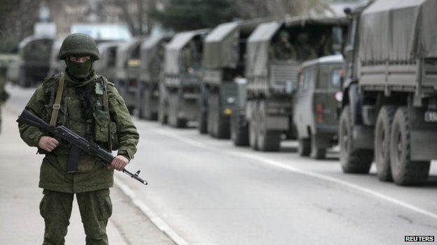 File photo: Armed Russian soldier stands near Russian army vehicles outside a Ukrainian border guard post in the Crimean town of Balaclava, 1 March 2014