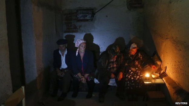 Local residents sit in a basement used as a shelter from artillery fire, in the village of Spartak, on the outskirts of Donetsk, Ukraine, 1 September 2014