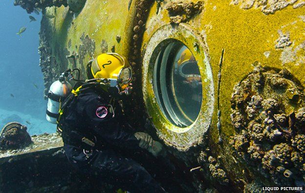 Diver looks through porthole