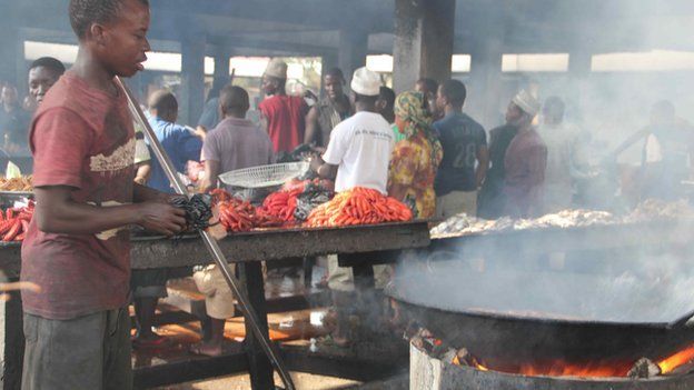 A man prepares fish dishes at Dar es Salaam's fish market, Tanzania