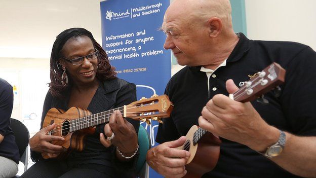 Woman teaching man to play ukulele