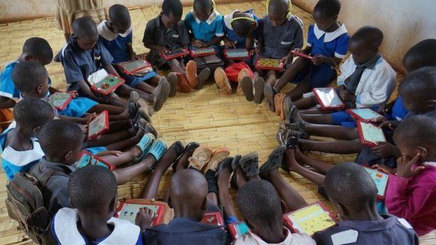 Children in Malawi sit in circle playing app