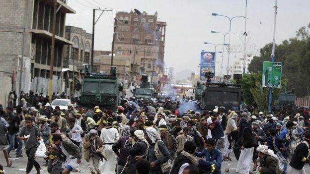 Houthis flee as riot police use tear gas to disperse them along a main road leading to the airport in Sanaa September 7