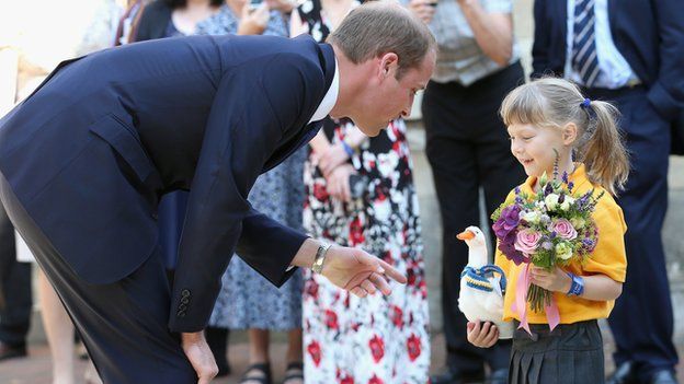 Prince William receives flowers from a young girl