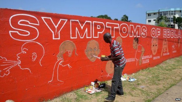 A street artist, Stephen Doe, paints an educational mural to inform people about the symptoms of the deadly Ebola virus in the Liberian capital Monrovia, 8 September 2014