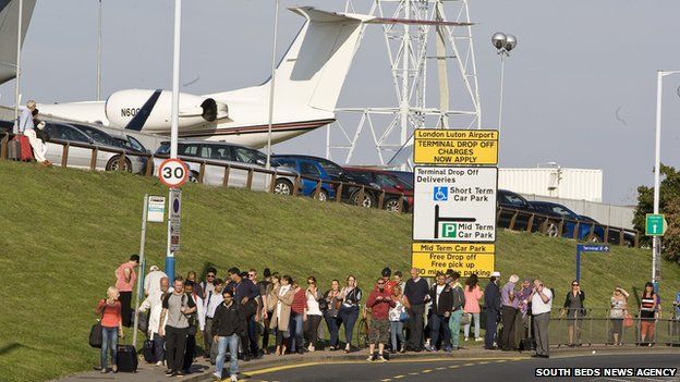 Passengers outside Luton Airport