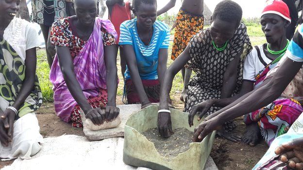 Women grind the seeds of lilies in Reke village, South Sudan (September 2014)