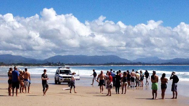 This photo taken by ABC News on 9 September 2014 shows people gathered at Australia's Clarke Beach in Byron Bay moments after the attack took place