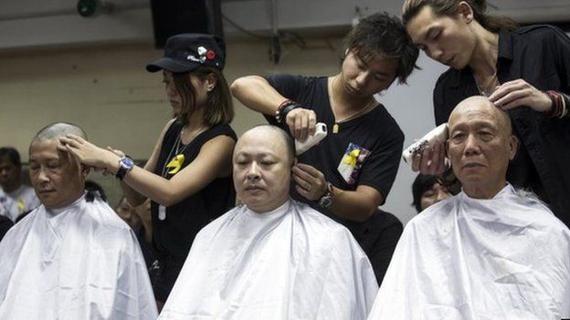 Founders of the Occupy Central civil disobedience movement (from L to R), academic Chan Kin-man, academic Benny Tai and Reverend Chu Yiu-ming, shave their heads during a protest to call for people to join them for an upcoming "Occupy Central" movement rally in Hong Kong 9 September 2014.