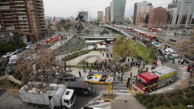 Emergency responders outside the Escuela Militar metro station after an explosion in Santiago (8 September 2014)