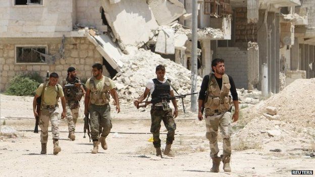 Free Syrian Army fighters walk together in the southern part of Maarat al-Nouman, Idlib province (July 2014)