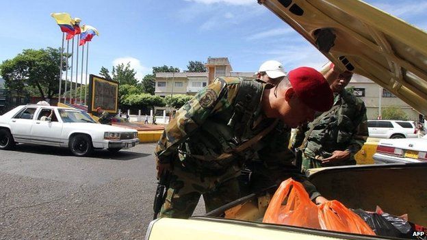 Venezuelan troops search for smuggled goods in a car heading to Colombia in the border city of San Cristobal (20 August 2014)