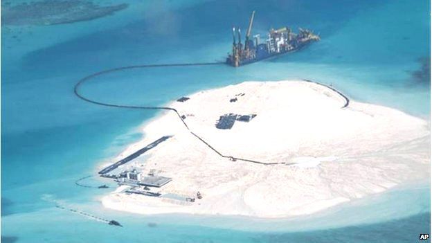 In this 25 Feb 2014 file photo taken by surveillance planes and released 15 May by the Philippine Department of Foreign Affairs, a Chinese vessel, top centre, is used to expand structures and land on the Johnson Reef, called Mabini by the Philippines and Chigua by China, at the Spratly Islands in the South China Sea, Philippines.
