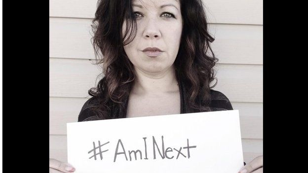 Woman holds "Am I next" sign?