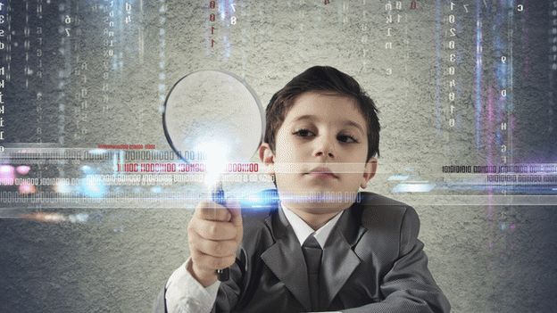 Boy looking for code with magnifying glass