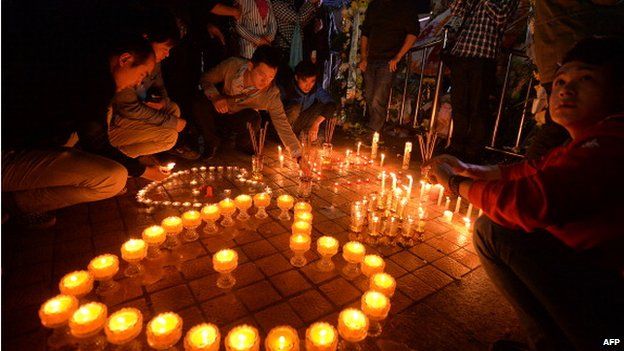 Chinese mourners light candles at the scene of the terror attack at the main train station in Kunming, Yunnan Province on 2 March 2014