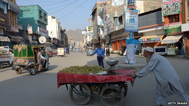 A Pakistani man pushes his fruit cart at a market in Mingora on 11 October 2013, the hometown of education activist Malala Yousafzai.
