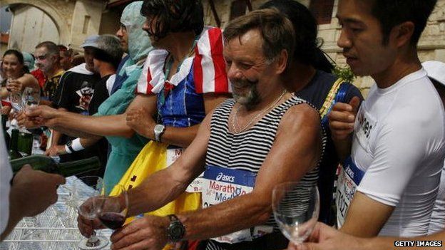 Runners enjoy wine at a chateau during a food and wine break