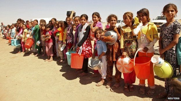 Displaced people from the minority Yazidi sect, fleeing violence in the Iraqi town of Sinjar west of Mosul, line up to receive food at a refugee camp - 13 September 2014