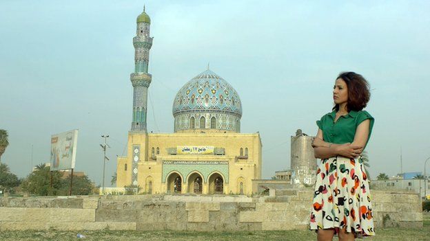 a lady in front of a mosque