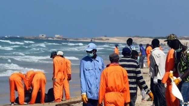 Rescuers collect the bodies of African would-be migrants that were washed up on the shore of al-Qarboli, east of Tripoli, Libya, 25 August 2014.
