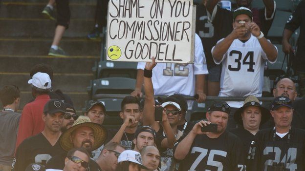 An Oakland Raiders fan holds a sign for NFL commissioner Roger Goodell after the game against the Houston Texans