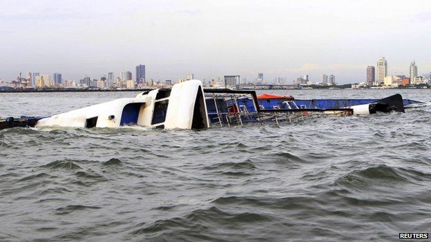 The Super Shuttle Ferry 7 floats on its side after it capsized in strong winds and huge waves unleashed by Typhoon Kalmaegi, locally named Luis, in Manila Bay on 15 September 2014