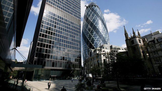 London city workers walk between buildings as 30 St Mary's Axe nicknamed The Gherkin, is pictured on September 18, 2006 in London, England. The famous London landmark standing at 180 metre high,