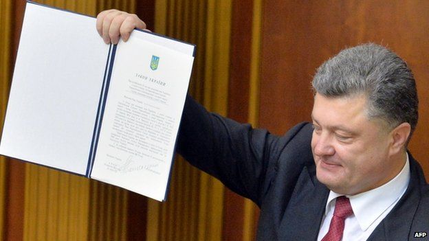 Ukrainian President Petro Poroshenko shows a newly-voted Ukrainian law about the ratification of the Ukraine-EU deal