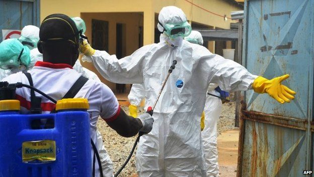 Guinea's Red Cross health workers wearing protective suits prepare to carry the body of a victim of Ebola at the NGO Medecin Sans Frontieres Ebola treatment centre near the hospital Donka in Conakry, 14 September 2014