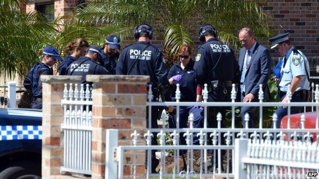Forensic experts collect evidence from a house in the Guildford area of Sydney on 18 September 2014