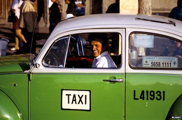 Taxi driver in one of Mexico City's distinctive green VW beetles