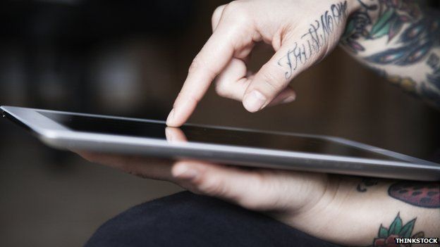 Tattooed person using tablet