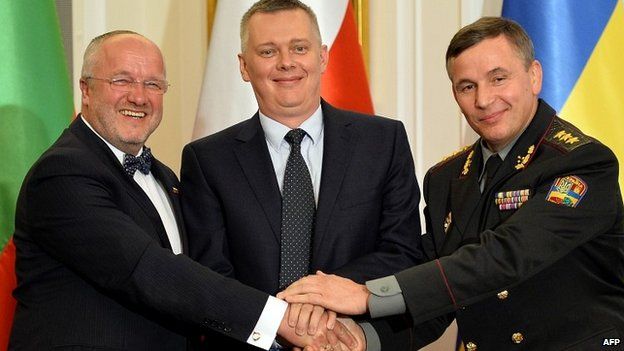 Ukrainian Defence Minister Valeriy Heletey (R), his Polish counterpart Tomasz Siemoniak (C) and Lithuanian counterpart Juozas Olekas (L) shake hands after signing an agreement on the creation of a joint military brigade - 19 September 2014