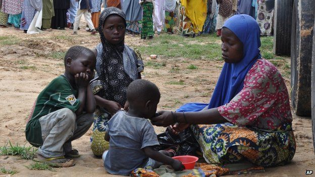 A woman and her children who fled their home following an attack by Islamist militants in Bama take refuge at a school in Maiduguri, Nigeria, on 9 September 2014
