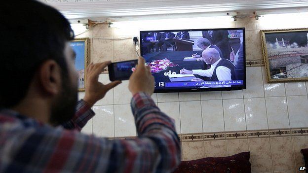 Man in Kabul watches power-sharing deal ceremony on TV. 21 Sept 2014