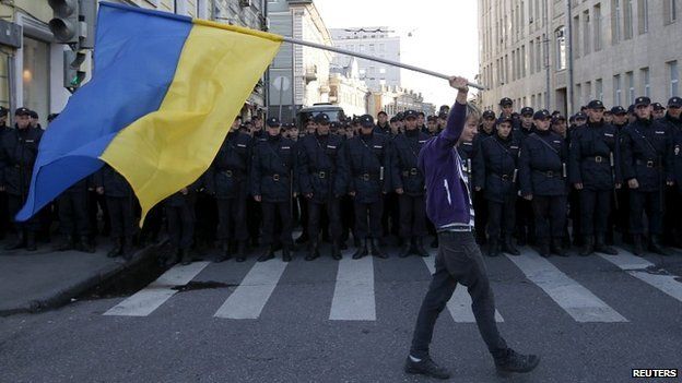 A man with a Ukrainian flag walks past police during an anti-war rally in Moscow - 21 September 2014