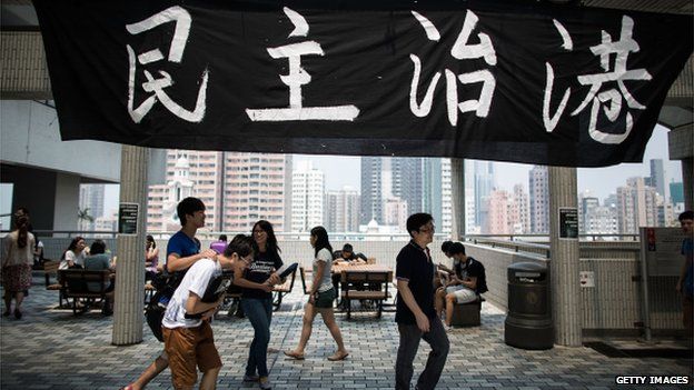Students of The University of Hong Kong gather in front of a banner with Chinese characters that read ''Democracy in Hong Kong'' at its Sun Yat-sen Place at campus on 19 September 2014 in Hong Kong.