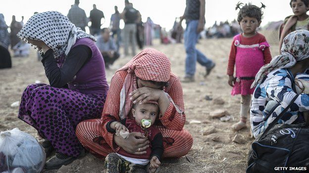 Syrian Kurds wait near Syria border at the south-eastern town of Suruc in Sanliurfa province, on 20 September 2014.