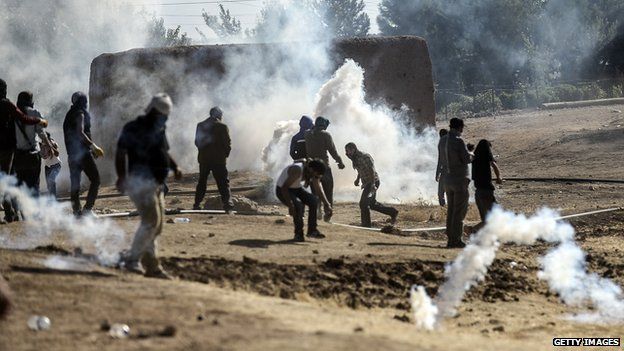 Kurdish protestors clash with Turkish soldiers near the Syrian border after Turkish authorities temporarily closed the border near the south-eastern town of Suruc in Sanliurfa province, on 22 September 2014.