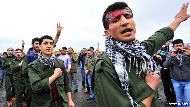 Turkish Kurds youth dressed as PKK (Kurdistan Workers Party) guerrilla uniform gesture during a gathering to celebrate Noruz, the Kurdish New Year, on 20 March 2011 in Istanbul.