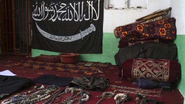 A black Jihad flag, handcuffs and chains are displayed in a house used by Taliban militants as a prison after a military operation against the militants in the town of Miranshah in North Waziristan July 9, 2014