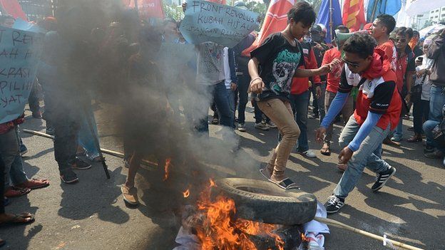 Protesters burn tyres outside parliament in Jakarta. 25 Sept 2014