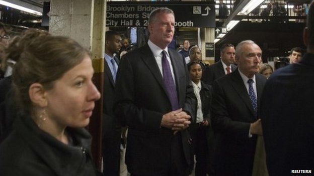 New York Mayor Bill de Blasio (C on left) and New York City Police Commissioner William Bratton (C on right) wait to take a subway train while on their way to give a news conference in New York 25 September 2014