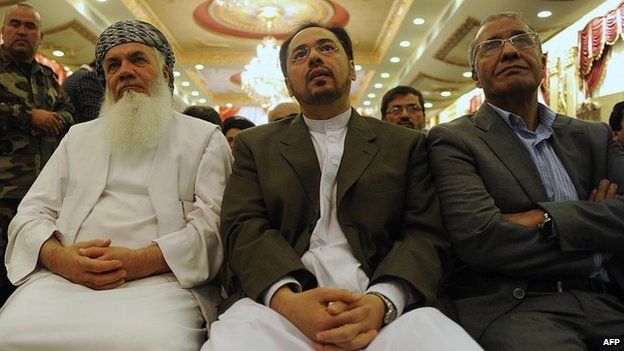 Newly appointed caretaker for the Jamiyat-i-Islami party Salahuddin Rabani (C), son of Burhanuddin Rabani, and Afghan Energy Minister Mohammad Ismail Khan (L) attend a ceremony for Salahuddin in Kabul on October 4, 2011