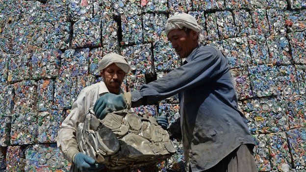 Afghan day-labourers load recyclable can