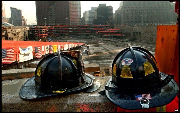 Firefighters helmets sit on a concrete ledge overlooking Ground Zero in 2002