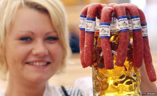 Oktoberfest waitress with tankard containing beer and sausages